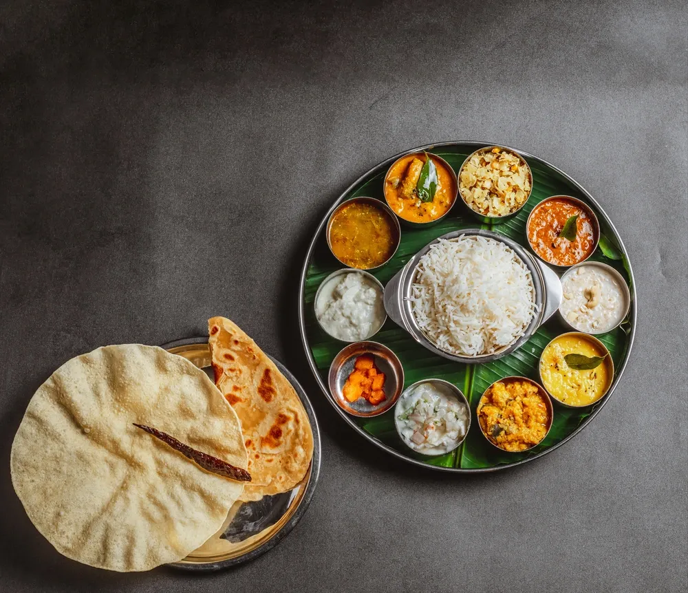 A generous South Indian vegetarian meal served on a banana leaf